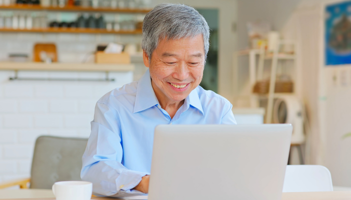 Senior man sitting at laptop computer