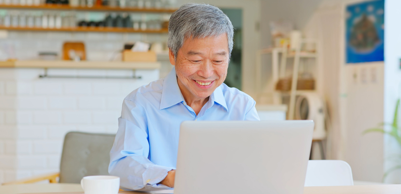 Senior man sitting at laptop computer