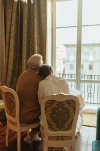 plan your estate, image of a senior couple huddled together looking out a window wistfully.