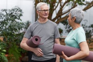 estate planning inaction, image of senior couple holding yoga mats chatting
