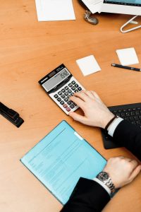 Is There a California Estate Tax, image of hand using a calculator on a desk