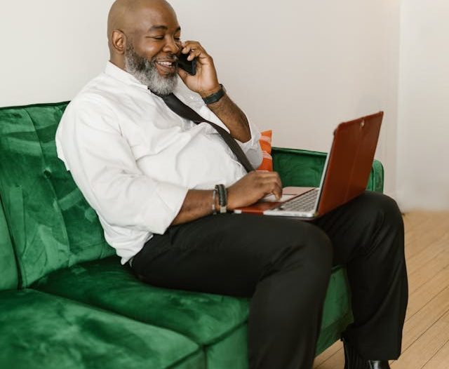 trusts in estate planning, image of a corpulent man wearing a tie talking on the phone while using a laptop